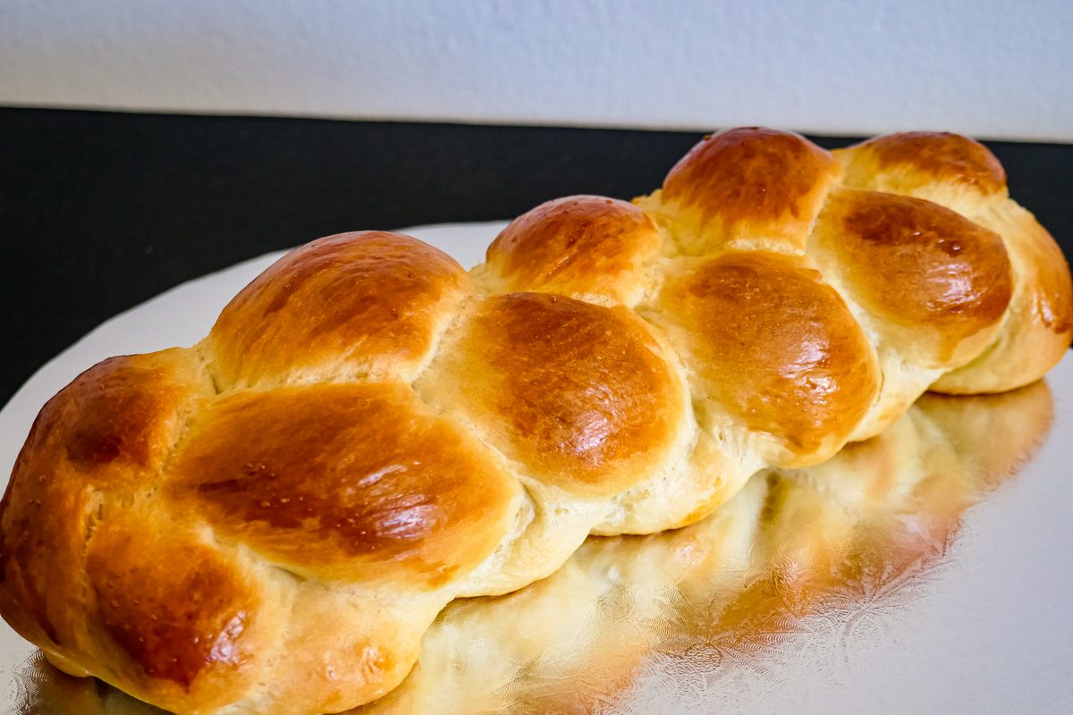 Golden braided challah loaf, baked fresh weekly