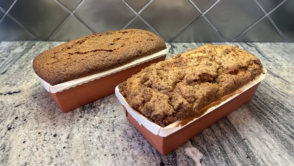 Two freshly baked loaf cakes in paper baking pans
